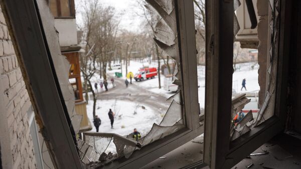 Окно жилого дома, получившего повреждения в результате обстрела ВСУ Донецка