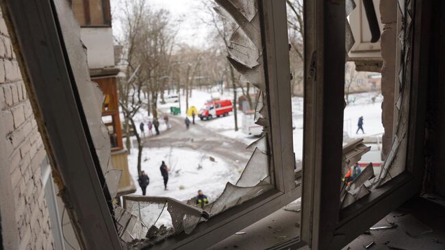 Окно жилого дома, получившего повреждения в результате обстрела ВСУ Донецка