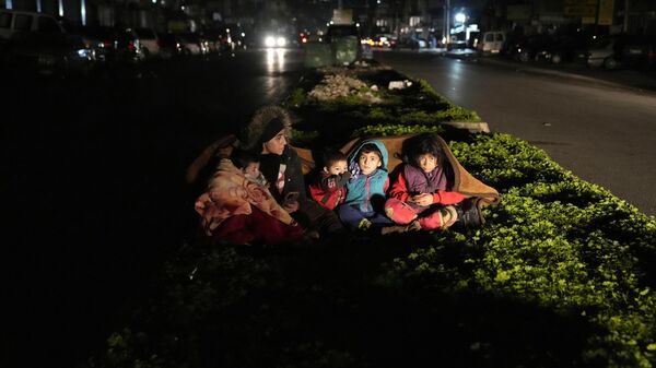 Семья возле своего дома после землетрясения в Турции