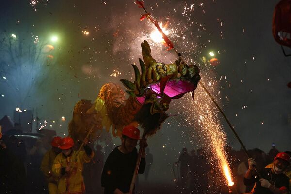 Артисты исполняют танец дракона во время праздника фонарей в Даньчжае, провинция Гуйчжоу