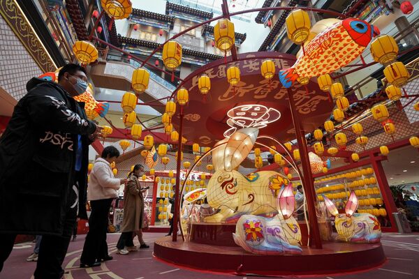 Покупатели в торговом центре Пекина, украшенном к празднику фонарей
