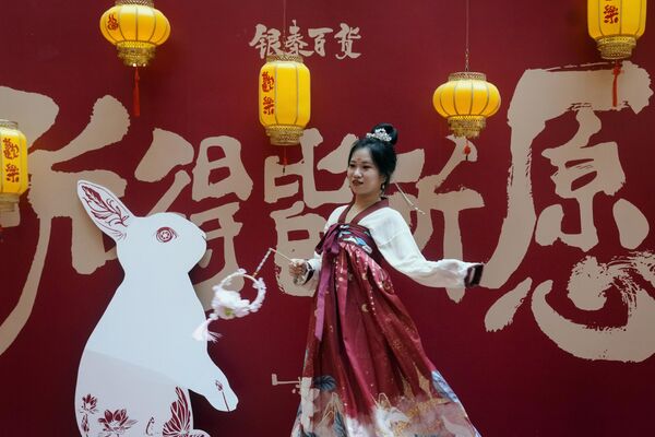 Девушка в национальной одежде во время праздника фонарей в торговом центре Пекина