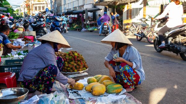 Женщина продает папайю на рынке в Нячанге