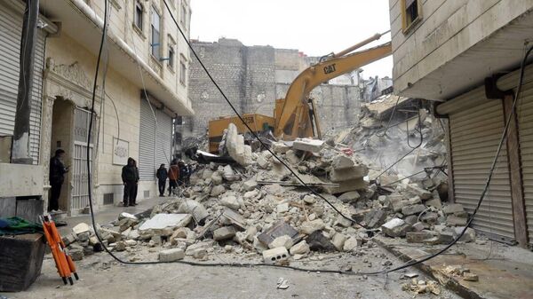 Строительная техника во время разбора завалов разрушенного в результате землетрясения жилого дома в сирийском Алеппо