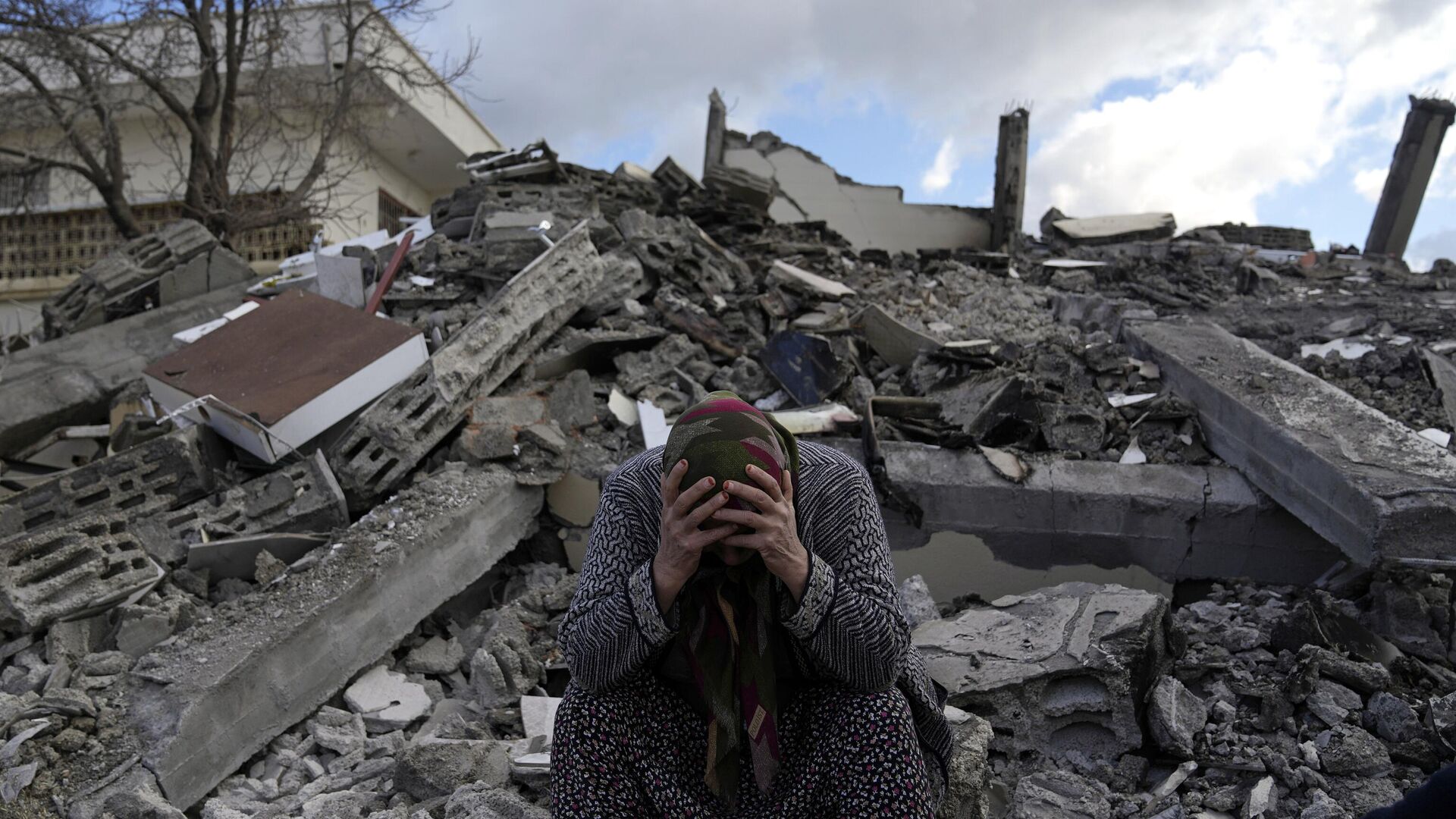 Женщина на месте обрушения дома в результате землетрясения в турецком городе Нурдагы - РИА Новости, 1920, 13.02.2023