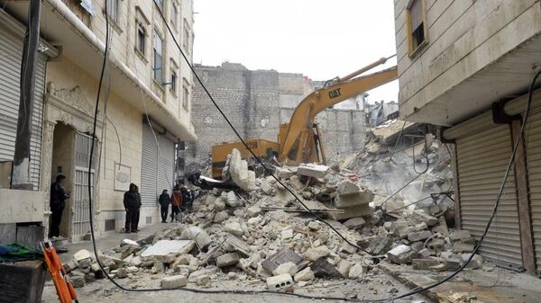 Строительная техника во время разбора завалов разрушенного в результате землетрясения жилого дома в сирийском Алеппо