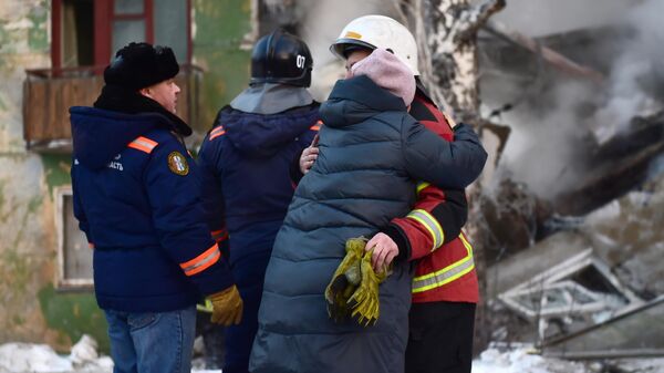Женщина обнимает спасателя на месте взрыва газа в пятиэтажном жилом доме на улице Линейная в Новосибирске