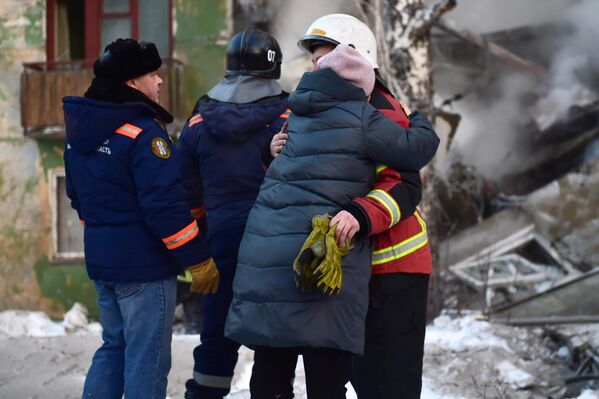 Женщина обнимает спасателя на месте взрыва газа в пятиэтажном жилом доме на улице Линейная в Новосибирске