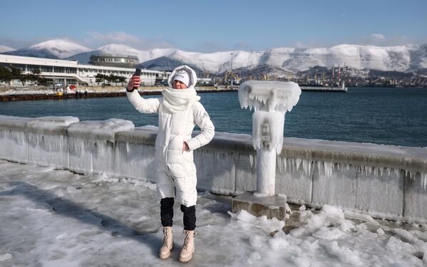 Девушка фотографируется на обледеневшей набережной адмирала Серебрякова в Новороссийске