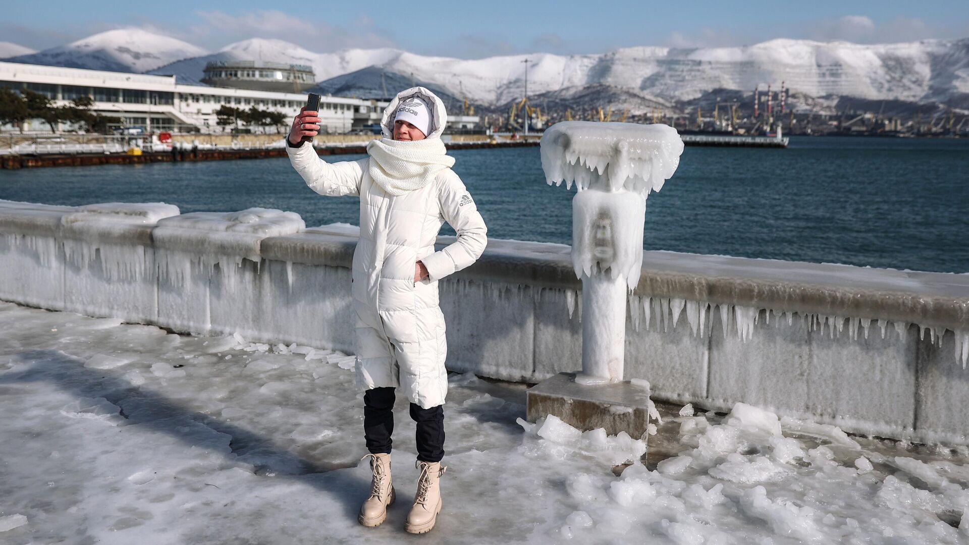 Девушка фотографируется на обледеневшей набережной адмирала Серебрякова в Новороссийске - РИА Новости, 1920, 09.02.2023