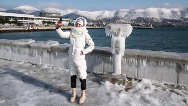 Девушка фотографируется на обледеневшей набережной адмирала Серебрякова в Новороссийске