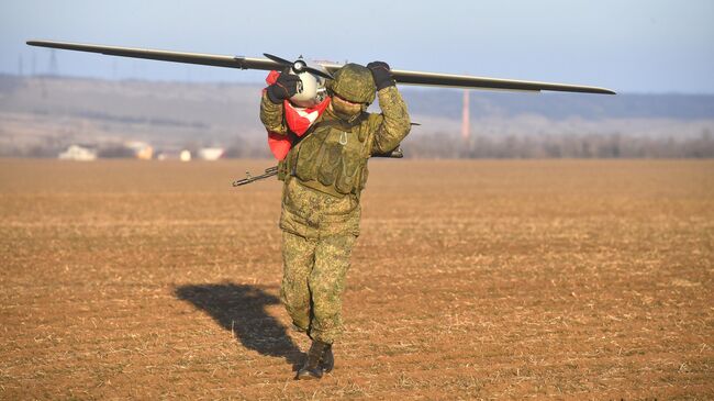 Военнослужащий ВС РФ выносит беспилотный летательный аппарат Орлан-10У после выполнения задачи в южном секторе СВО