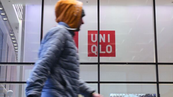 Прохожий у закрытого магазина одежды Uniqlo в Санкт-Петербурге