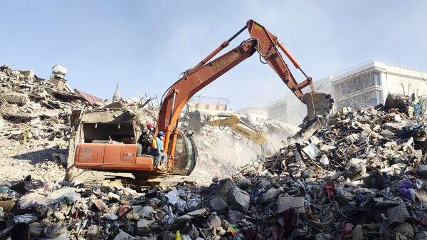 Разбор завалов на месте разрушенного в результате землетрясения здания в турецком Кахраманмараше