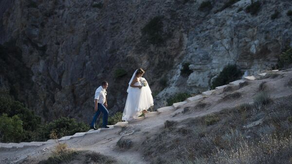Свадебная пара поднимается на мыс Фиолент в Крыму