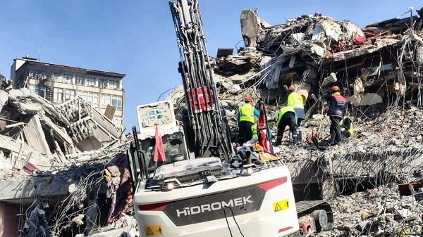 Разбор завалов на месте разрушенного в результате землетрясения здания в турецком городе Кахраманмараш