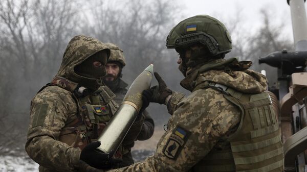 Украинские военные заряжают британскую гаубицу L119