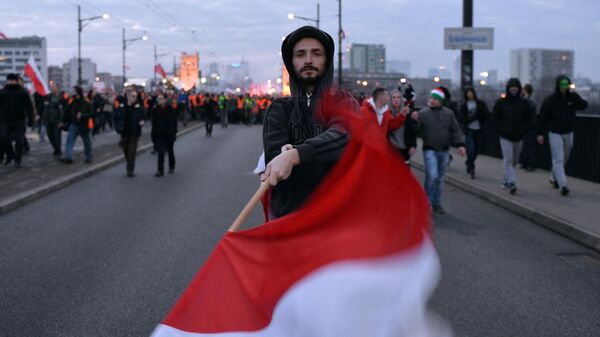 Мужчина с флагом Польши в Варшаве 