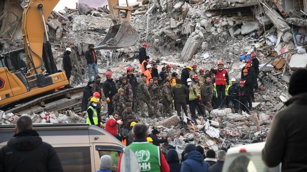 Спасатели на месте разрушенного при землетрясении здания в Турции