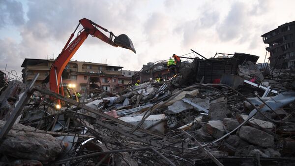 Разбор завалов на месте разрушенного в результате землетрясения здания в Турции