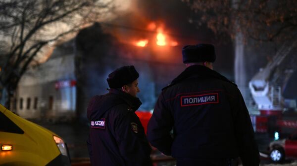 Сотрудники полиции на месте возгорания в техцентре на улице Декабристов в Москве