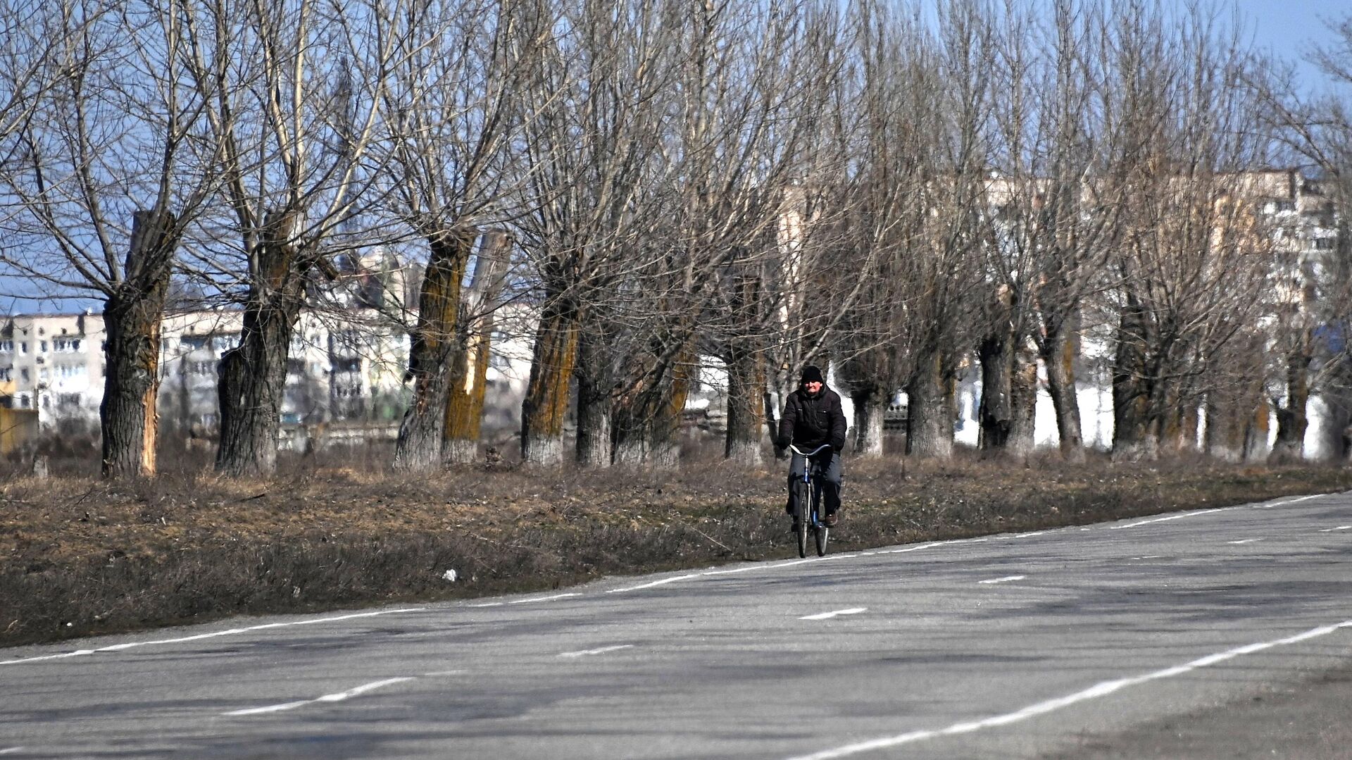 Мужчина едет на велосипеде в Новой Каховке - РИА Новости, 1920, 27.02.2023