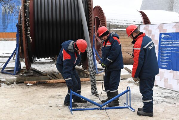 Рабочие надевают проволочный чулок перед монтажом кабеля в рамках реконструкции ТЭЦ Елоховская