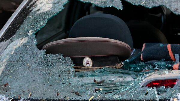 Военная фуражка в салоне автомобиля, поврежденного в результате обстрела со стороны ВСУ, в центре Донецка