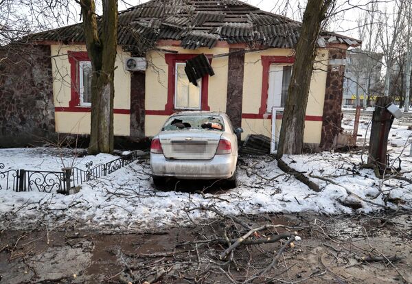 Дом и легковой автомобиль, поврежденные в результате обстрела со стороны ВСУ, в центре Донецка