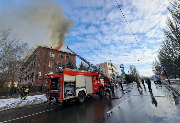 Сотрудники противопожарной службы тушат пожар, возникший в результате обстрела со стороны ВСУ, в здании Генеральной прокуратуры в Донецке