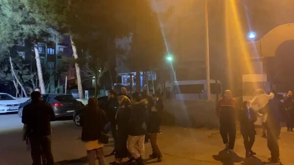 Люди на улице в турецкой провинции Хатай после новых подземных толчков