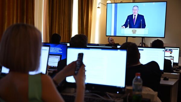 Журналисты смотрят трансляцию ежегодного послания президента РФ Владимира Путина к Федеральному собранию