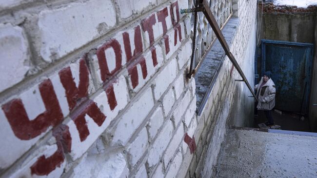 Женщина спускается в бомбоубежище во время воздушной тревоги на Украине 