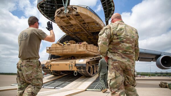 Американские военнослужащие грузят танк M1 Abrams на военно-транспортный самолет 