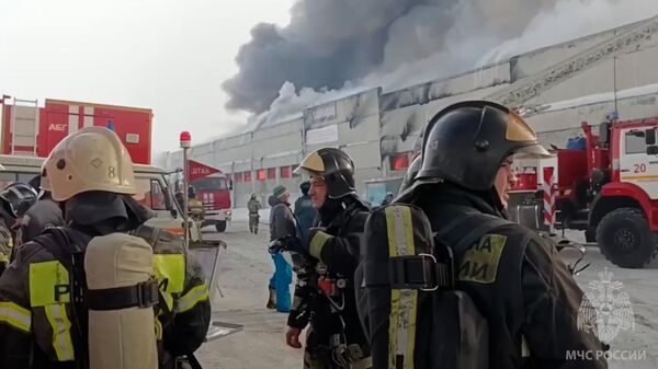Работа пожарных на месте возгорания в складском здании Красноярска