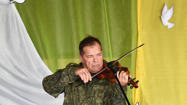 Музыкант, экс-скрипач рок-группы Аквариум Андрей Решетин выступает перед бойцами в зоне СВО