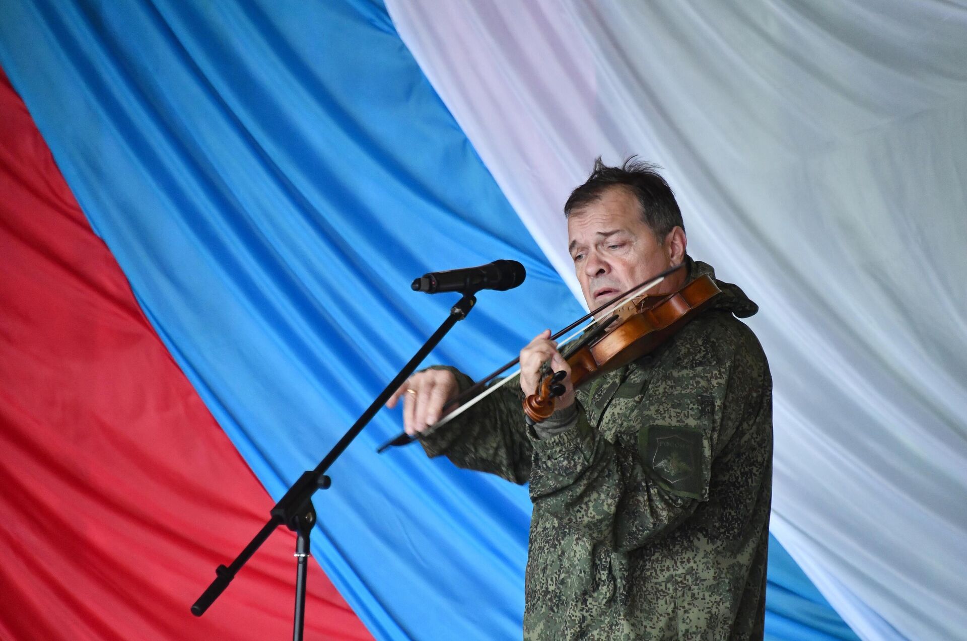 Музыкант, экс-скрипач рок-группы Аквариум Андрей Решетин выступает перед бойцами в зоне СВО - РИА Новости, 1920, 22.12.2023