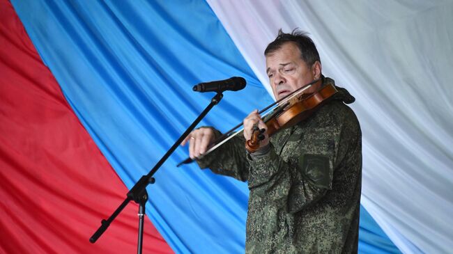 Музыкант, экс-скрипач рок-группы Аквариум Андрей Решетин выступает перед бойцами в зоне СВО