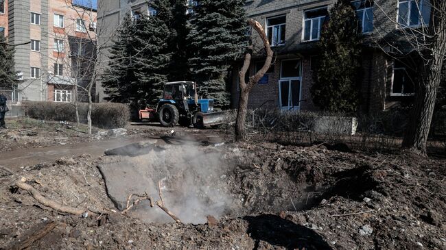 Воронка от разорвавшегося снаряда, упавшего в Донецке после обстрела со стороны ВСУ