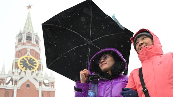 Туристы из Китая гуляют на Красной площади в Москве