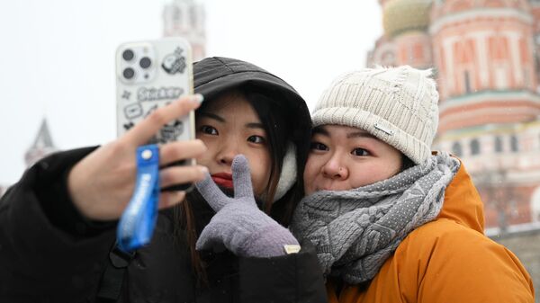 Туристки из Китая гуляют на Красной площади в Москве