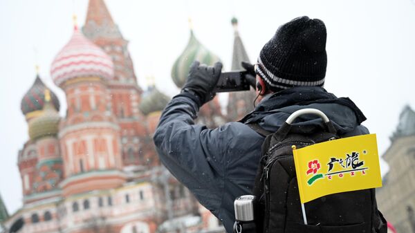 Турист из Китая гуляет на Красной площади в Москве