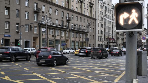 Автомобильное движение и светофор с секцией Белый пешеход на Тверской улице в Москве