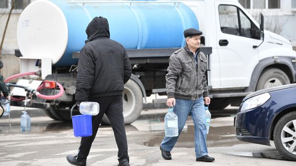 Люди набирают воду, привезенную в связи с аварией на центральном водоводе в Крыму