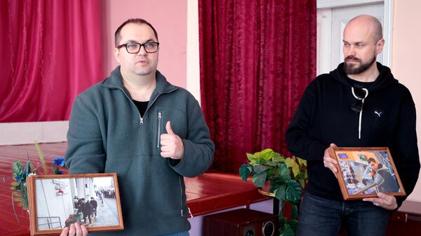 Журналисты РИА Новости передают фотографии школе №11 города Снежное Донецкой народной республики