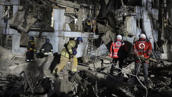 Украинские пожарные осматривают место падения ракеты на многоэтажку в Запорожье. 2 марта 2023