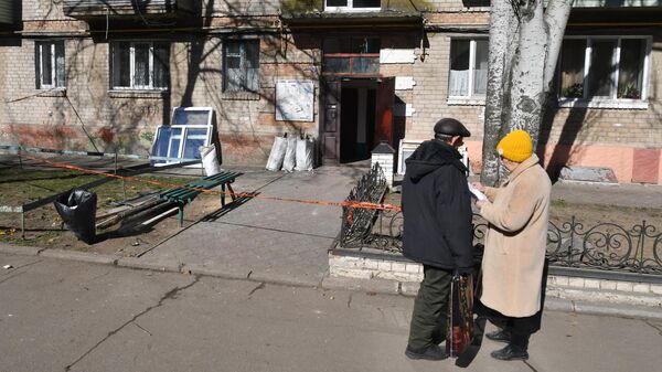 Жители у жилого дома в городе Днепрорудное в Запорожской области, получившего повреждения в результате атаки беспилотниками со стороны ВСУ