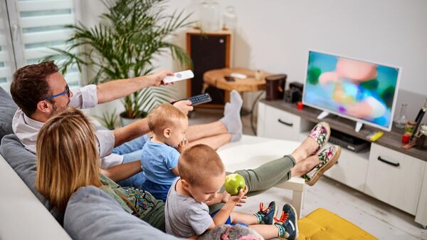 Семья с детьми смотрит телевизор