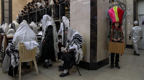 Ультраортодоксальные евреи читают свитки Эстер во время праздника Пурим в синагоге Бней-Брака, Израиль