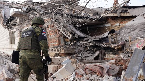 Сотрудник следственного комитета России фиксирует последствия обстрела украинскими войсками из РСЗО HIMARS